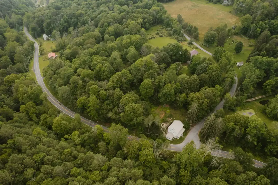 Aerial view of a winding road through wooded hills